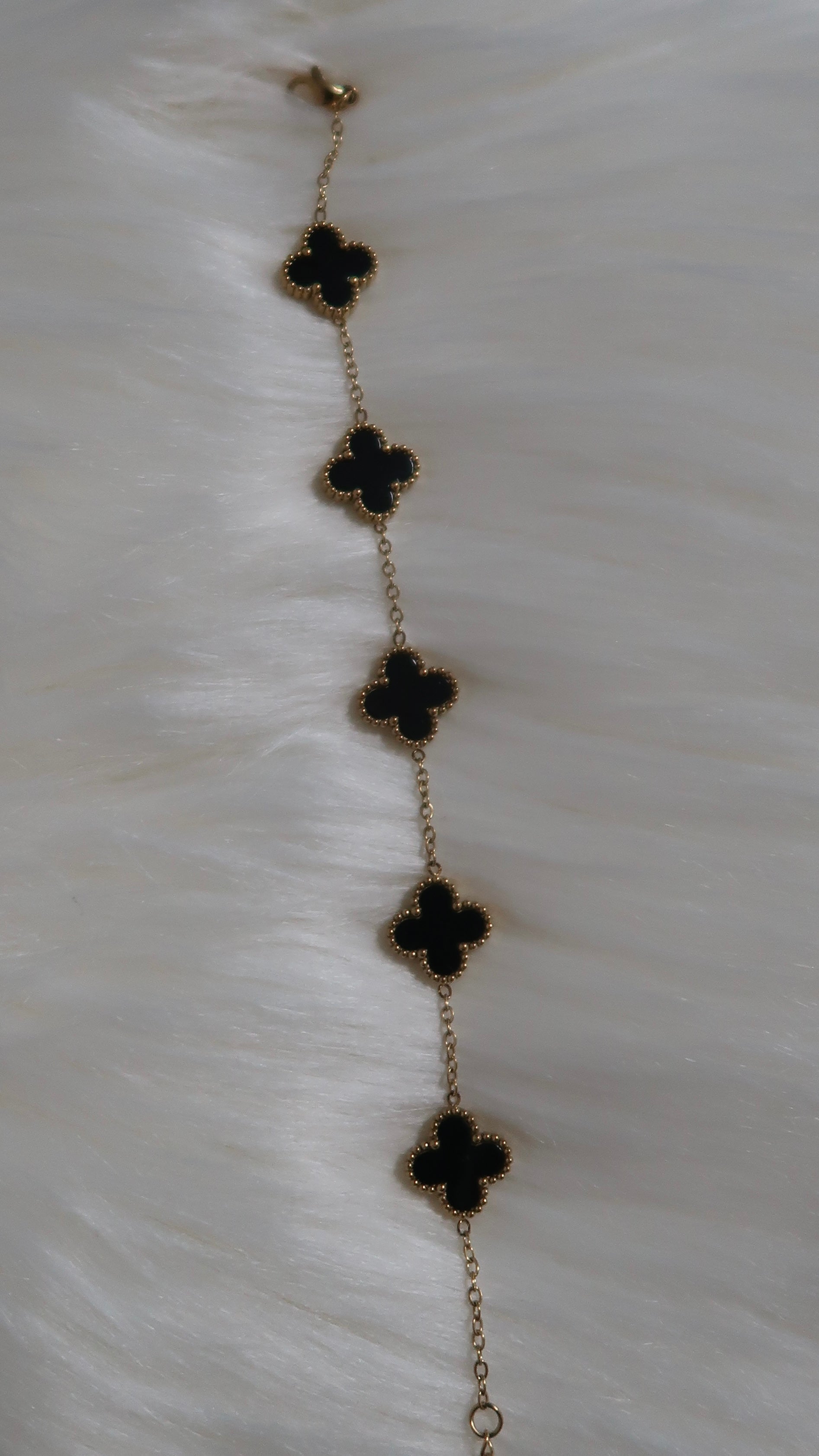 Gold/Schwarzes Armband mit Kleeblatt-Elementen