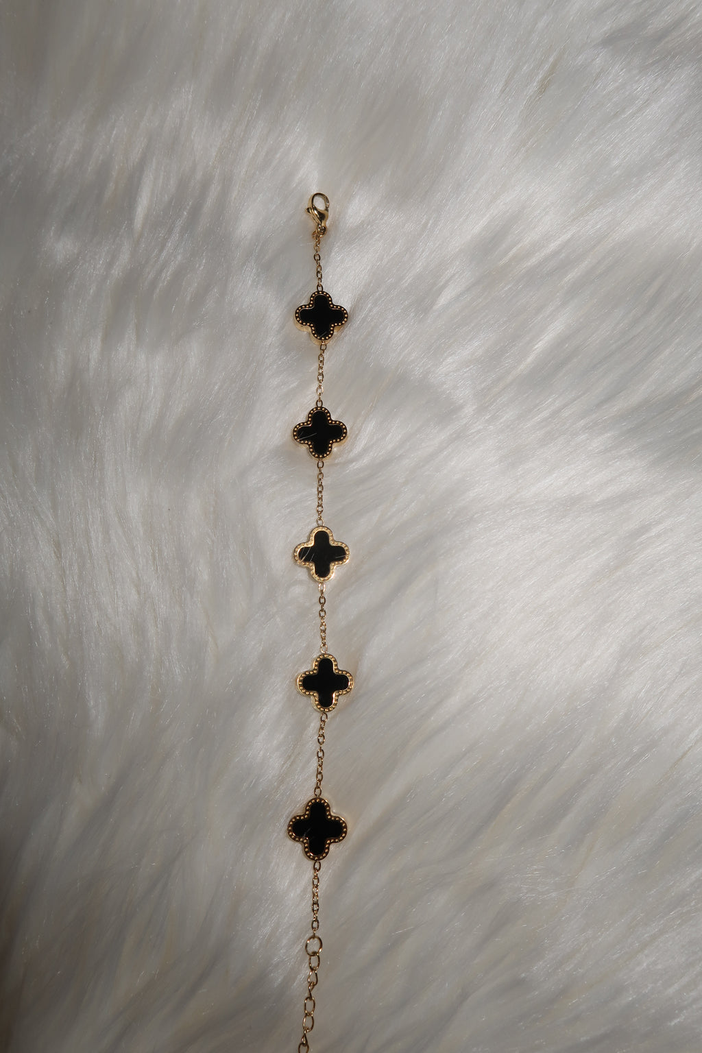 Gold/Schwarzes Armband mit Kleeblatt-Elementen