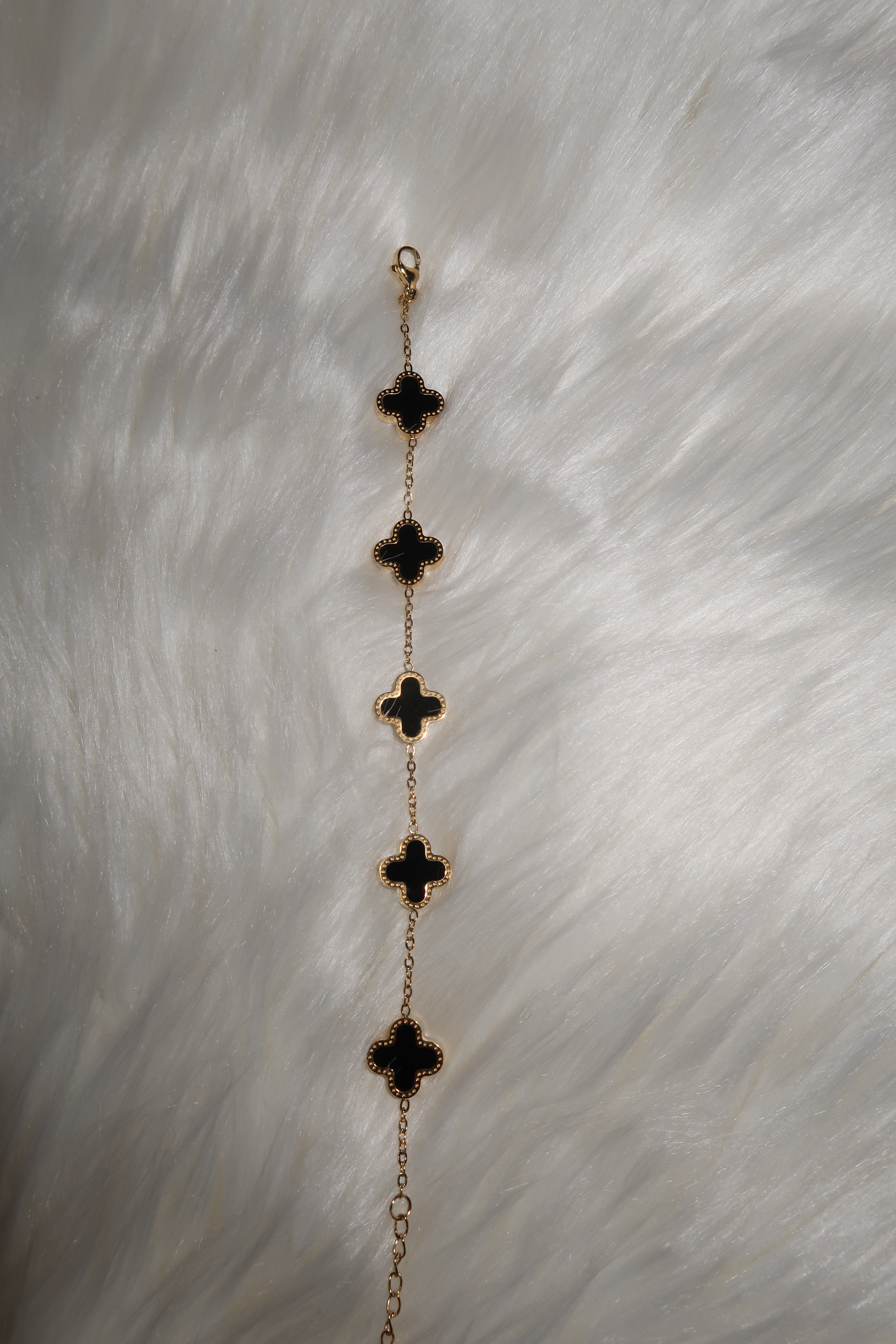 Gold/Schwarzes Armband mit Kleeblatt-Elementen